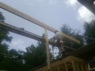 Carpenter setting a ridge beam over a new addition frame — Ice Dam Removal by Roofing Brothers in Shelby